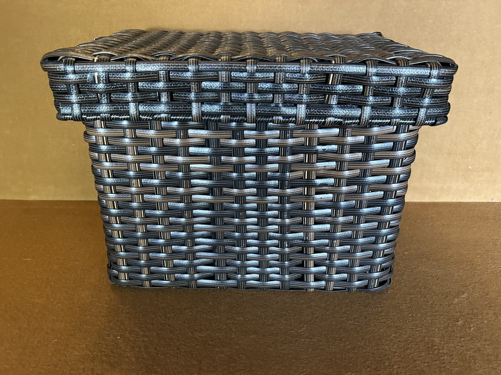 Large wicker weaved storage basket metal bar structure inside lift off lid brown